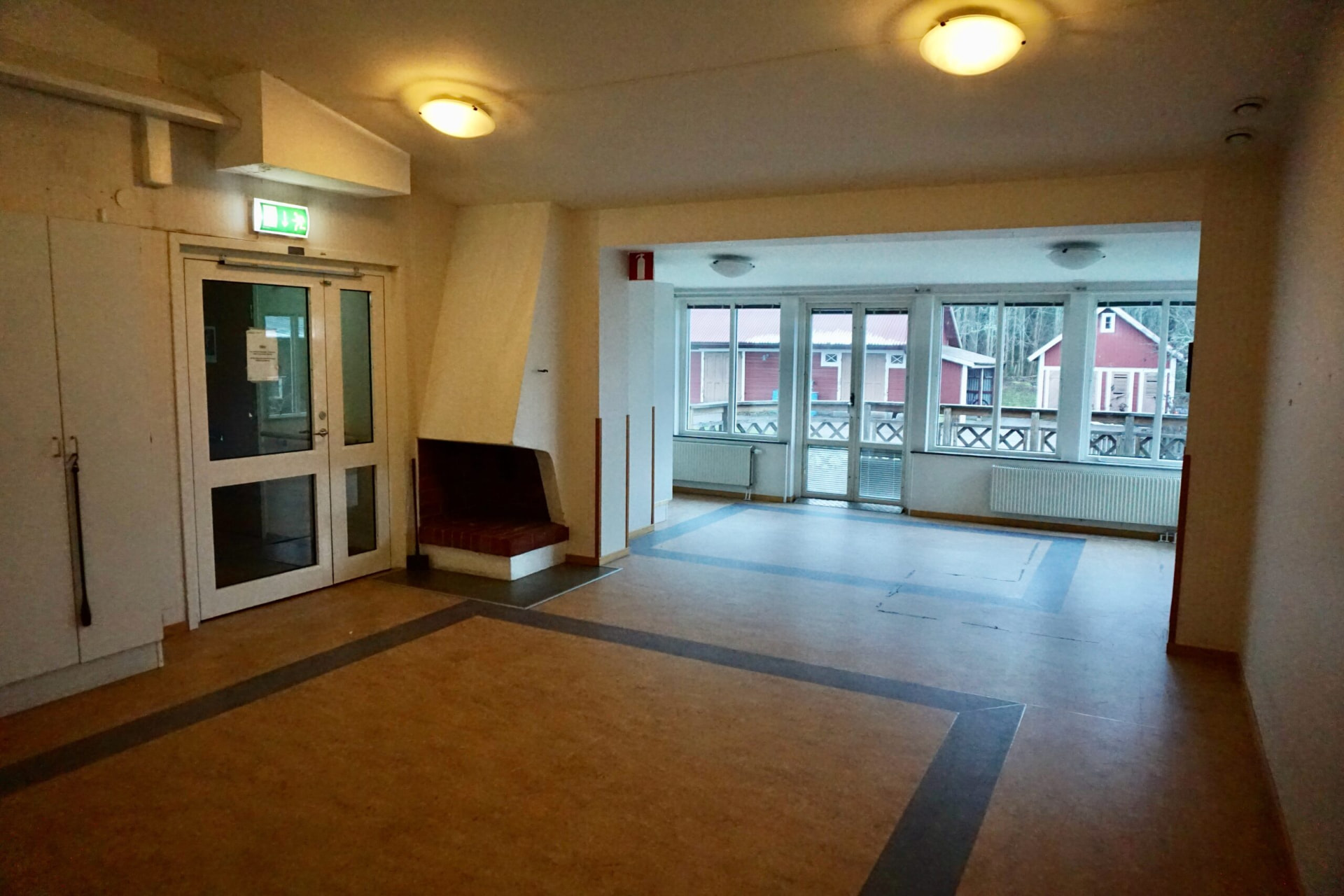 Stora Yxhult 1:26 – entréhall med öppen spis och glasparti mot uteplats